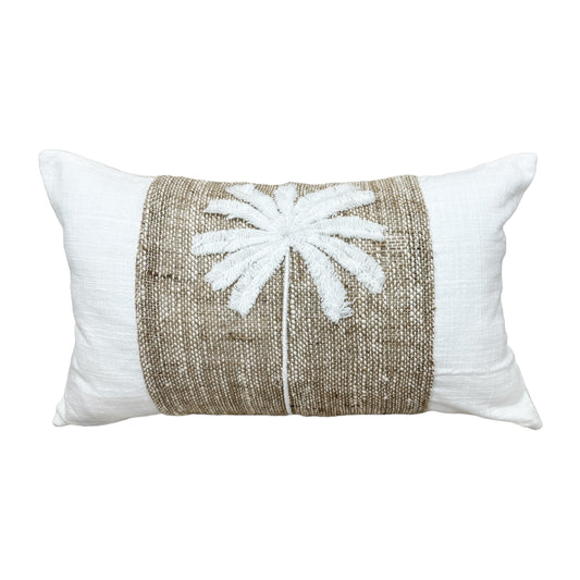 A rectangular lumbar throw pillow featuring a white textured fabric border and a central natural jute band with a white embroidered palm tree motif.